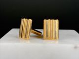 gold plated cufflinks on a white marble block