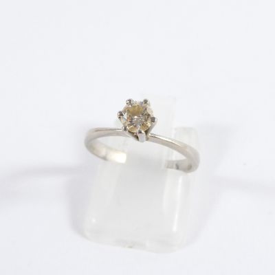 un gros plan d'une bague sertie d'un diamant sur un fond blanc