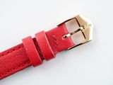 the strap is red and has a gold buckle on it