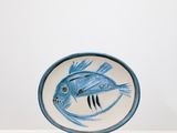 une assiette bleue et blanche ornée d'un motif de poisson