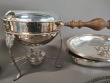 a silver plate with a wooden handle next to a silver plate with a wooden handle