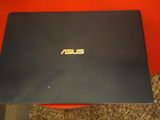 the asus laptop is sitting on top of a red chair