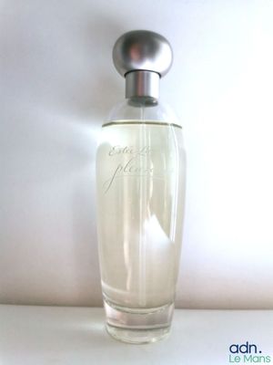 une image représentant un flacon de parfum posé sur une table