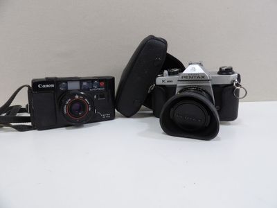 two cameras sitting on a table next to each other