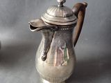 two silver teapots sitting next to each other on a table