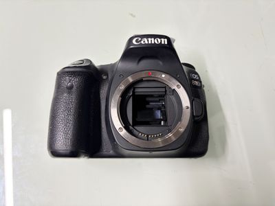 un appareil photo Canon posé sur une table à côté d'une tasse de café