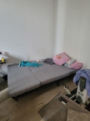 a small bed in the corner of a room next to a desk