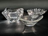 two clear glass bowls sitting on a black surface