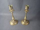 pair of antique brass candlesticks on a grey background