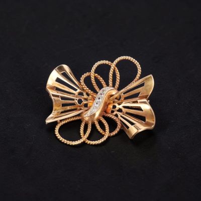 Broche en or 18k (750e), stylisant un noeud drapé décoré de … - Photo 1