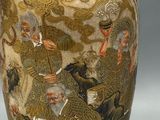 a gold vase with a picture of a man riding a horse on it