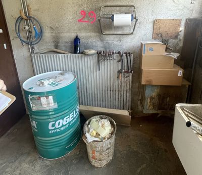 a green barrel sitting next to a trash can in a room