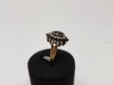 a gold and black diamond ring on a black velvet ring holder