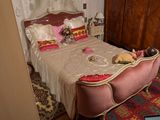 un lit avec une tête de lit rose dans une chambre