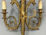 an image of a brass wall light with two candles on it