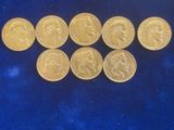 a close up of a bunch of gold coins on a blue surface