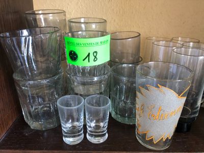 plusieurs verres et une bouteille d'alcool sur une étagère