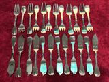 beaucoup de fourchettes et de cuillères posées sur une nappe rouge