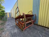 une photo d'un banc en bois devant un bâtiment jaune
