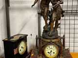 une statue représentant un garçon et une horloge posée sur une table