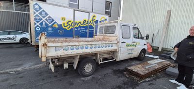 a man standing in front of a truck with a sign on it