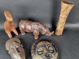 several different types of african masks and vases on a black surface