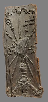une image représentant une plaque métallique ornée d'un soleil et d'une croix