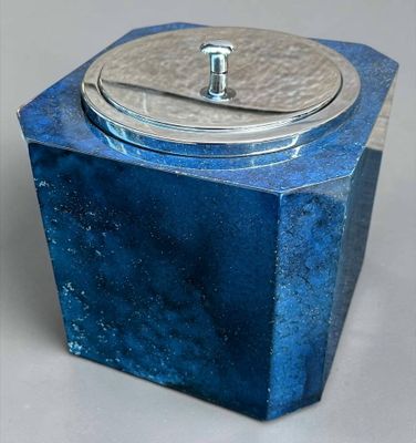 une petite boîte bleue avec un couvercle, posée sur une table