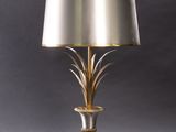 a brass table lamp with a white shade on top of it