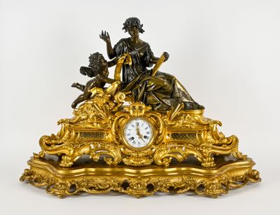 une horloge en or surmontée d'une statue