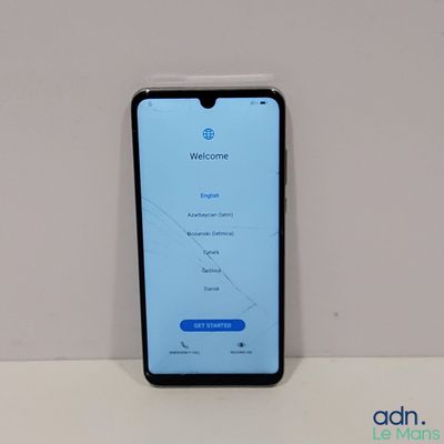 un gros plan d'un téléphone portable dont l'écran est cassé, posé sur une table