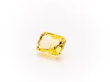 a yellow sapphire stone on a white background