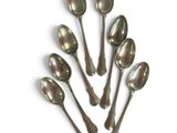 six spoons are arranged in a circle on a white surface