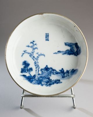 a blue and white plate with a landscape on it