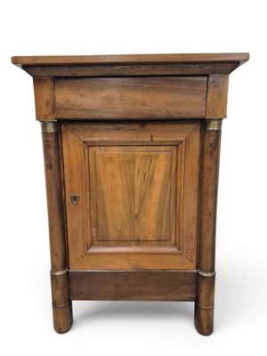 une vieille armoire en bois avec une porte et un tiroir au-dessus