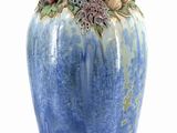 a blue vase that has a bunch of flowers on it