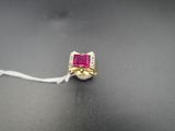 un gros plan d'une bague ornée d'une pierre rose sur un fond noir