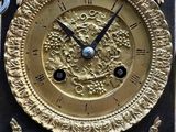 a black and gold clock sitting on the side of a building