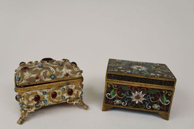 two pieces of jewelry sitting next to each other on a white surface