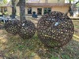 trois boules métalliques posées dans l'herbe