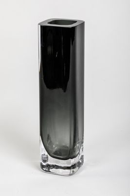 un vase noir posé sur une surface blanche