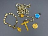 rosary, medal, and medallions are laid out on a table