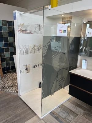 une salle de bains avec une porte de douche en verre et un lavabo