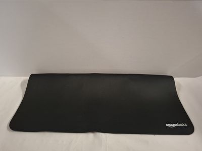 the back of a black computer mouse pad on a white surface