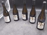 six bouteilles de vin sont alignées sur un comptoir