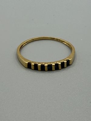 un gros plan d'une bague en or sertie de pierres noires