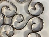 a picture of a metal wall decoration with swirly designs