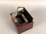 a small wooden box with a silver figurine in it