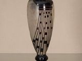 a black and white vase sitting on a glass table