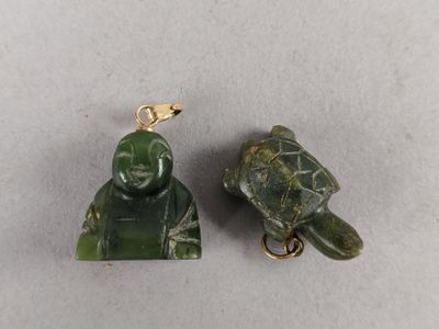 two pieces of green jade with a turtle on top of it